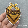 A yellow and brown embroidered patch shaped like a cowboy hat, shown being held in a hand.
