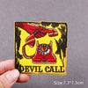 Embroidered patch featuring a red hand holding a red telephone and the text Devil Call on a yellow background