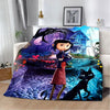An animated print blanket featuring a dark silhouette of a tree, a girl, and a black cat in a vibrant blue and purple landsca