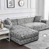 A gray elastic sofa cover protector with a black flower print pattern displayed on a sofa.