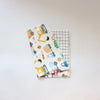 A white baby pillow cover featuring a colorful pattern of yellow and blue construction vehicles.