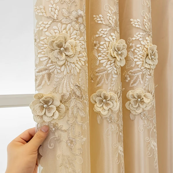 Close-up of a sheer beige lace curtain with floral embroidery hanging from a rod.
