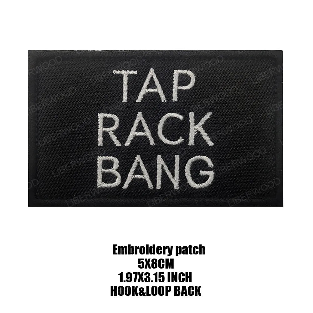 Black embroidered patch with white text saying TAP RACK BANG