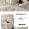 A set of soft white and lavender cotton duvet covers with a small terracotta pot on the bed.