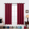 A set of two deep red blackout grommet curtains hanging in a window frame.