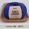A ball of royal blue 100% organic cotton yarn labeled QJH for knitting and crochet placed on a wooden tray.