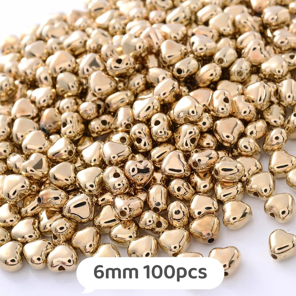 A pile of gold-colored, heart-shaped metal beads for jewelry making