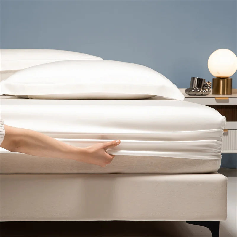 A hand gently touches white luxury bamboo bedding on a bed.