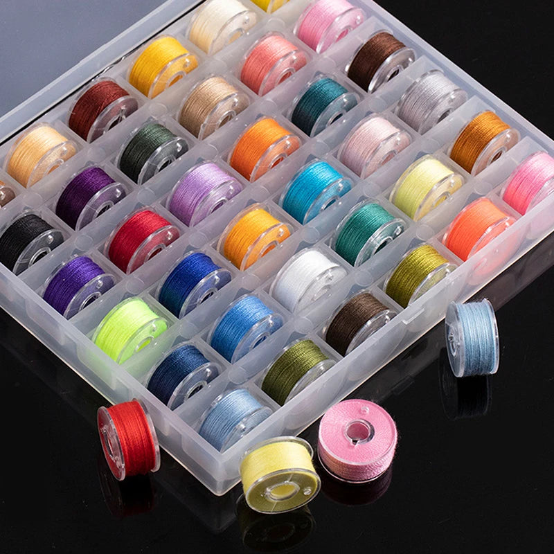 A clear plastic box filled with various colored sewing bobbins and thread spools.