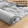 A rolled-up gray plush floor mat with a textured surface is shown on a wooden floor.