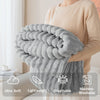 A person is holding a fluffy gray soft flannel throw blanket, highlighting its ultra soft, lightweight, breathable, and machi