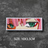 A square embroidered patch featuring a stylized female face with pink and orange hair and green eyes on a dark gray backgroun