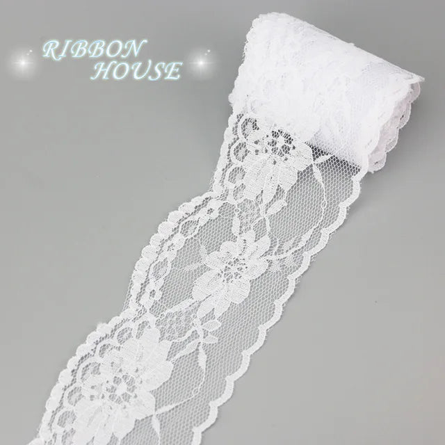 White decorative lace ribbon roll with a white fabric tip and floral pattern