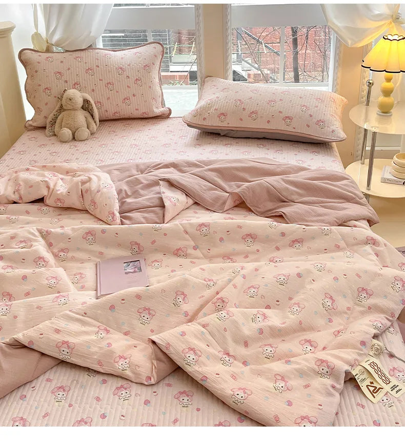A pink cartoon quilting comforter with a subtle pattern is displayed on a bed.