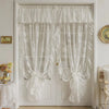 White sheer curtain with ruffled lace trim and vintage floral design hanging on a white door.