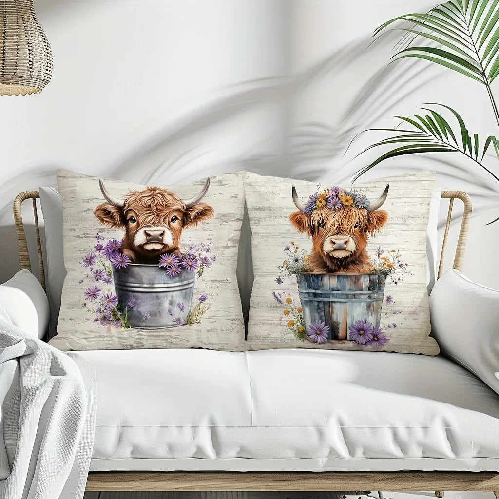 A decorative pillow cover featuring a print of an adorable Highland cow with floral accents.