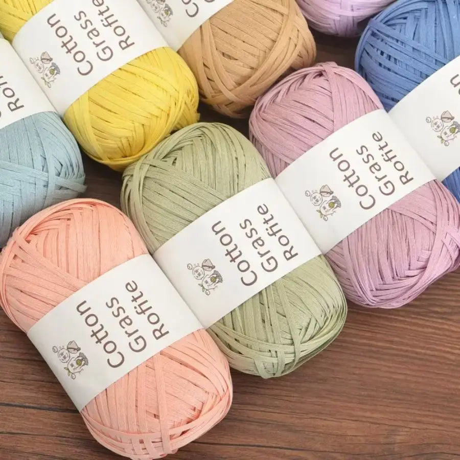 A collection of natural cotton grass yarn in various shades including yellow, light green, pink, and blue.
