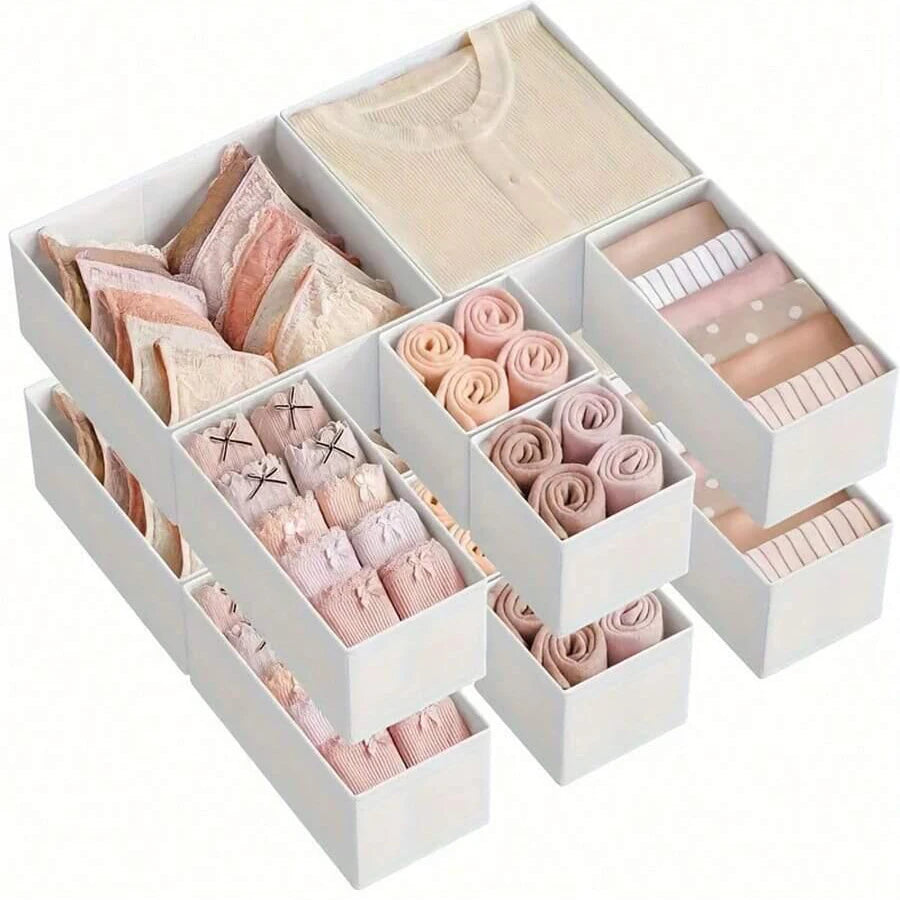A white foldable underwear organizer set with various shades of pink and beige fabric folded inside.
