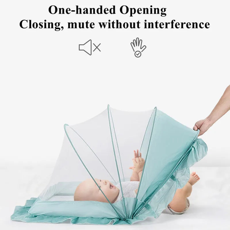 A baby is lying in a crib covered by a light blue foldable mosquito net for infant use.