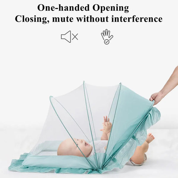 A baby is lying in a crib covered by a light blue foldable mosquito net for infant use.
