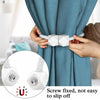 Hands are using magnetic curtain tiebacks to hold a blue patterned curtain.
