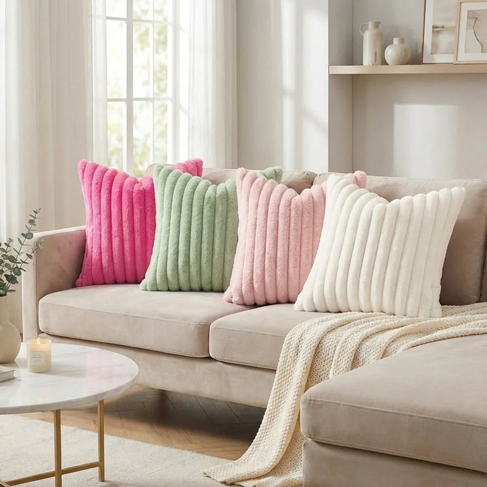 A collection of pink, green, and cream faux fur decorative throw pillows displayed on a beige sofa.