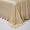 A smooth, beige luxury Egyptian cotton bed sheet draped elegantly on a white surface.