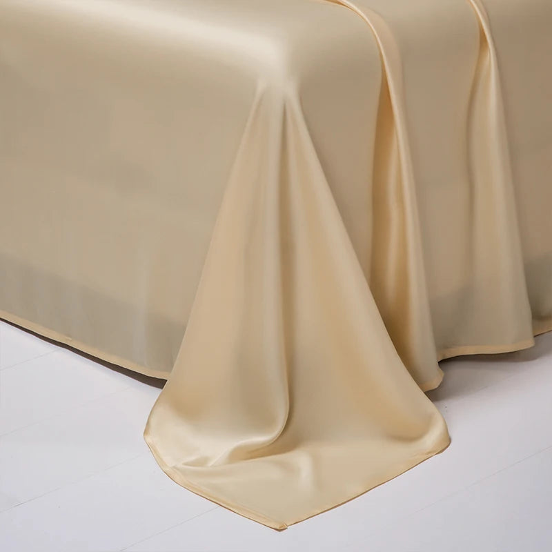 A smooth, beige luxury Egyptian cotton bed sheet draped elegantly on a white surface.