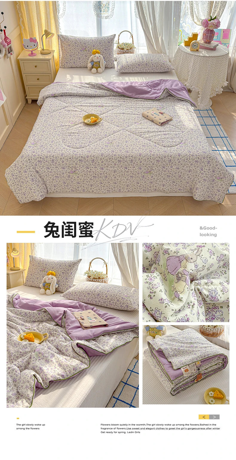 A purple and white cartoon pattern lightweight summer quilt displayed on a bed.