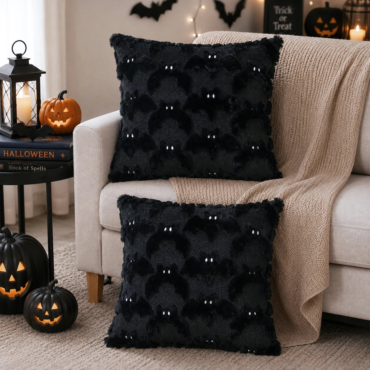 Black faux fur bat plush cushion cover used as Halloween decor on a sofa.