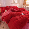 A vibrant red plush mink velvet duvet set with matching pillows on a bed.