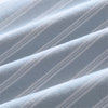 Close-up of a light blue cotton striped sleeping bag fabric showing diagonal pleats.