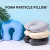 A collection of foam particle pillows in various shades of blue, gray, and beige are displayed on a white surface.