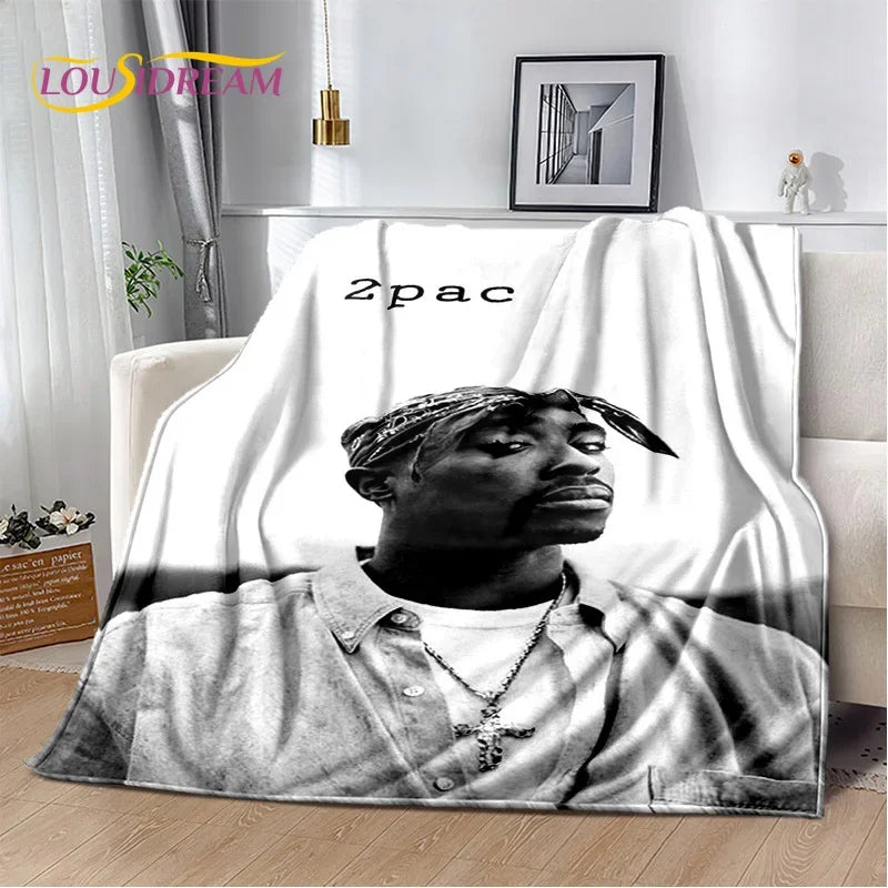 A black and white graphic throw blanket featuring a portrait of a man wearing a bandana and a shirt.