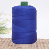 A spool of dark blue 3mm ice rope crochet yarn with a green cap resting on a woven mat.