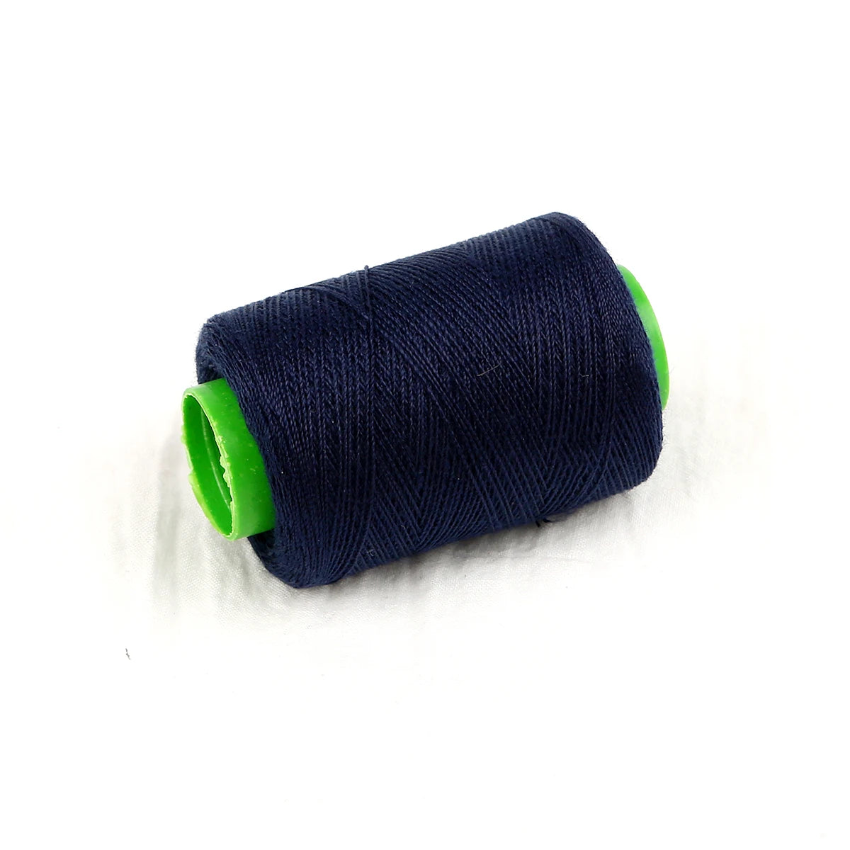 A spool of dark blue hand sewing thread with a bright green core.