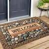 A rectangular stone doormat with the word WELCOME carved into it, placed on a wooden porch.