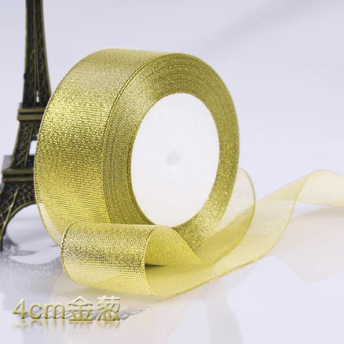 A roll of gold glitter organza ribbon used for gift wrapping and DIY crafts.