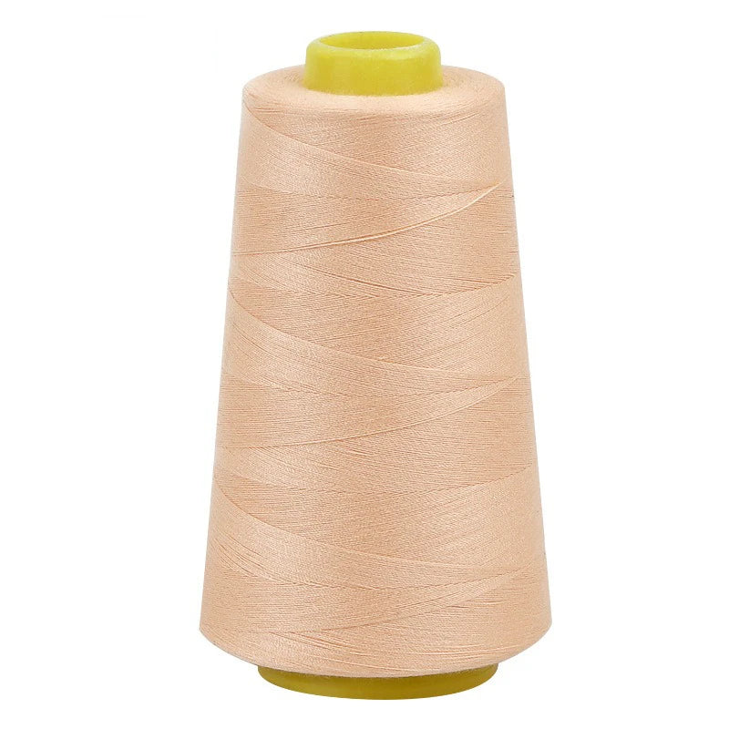 A roll of light beige sewing thread with a yellow core and plastic spool.
