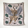 A throw blanket featuring a bohemian geometric pattern with tiger and leaf motifs in muted earth tones.