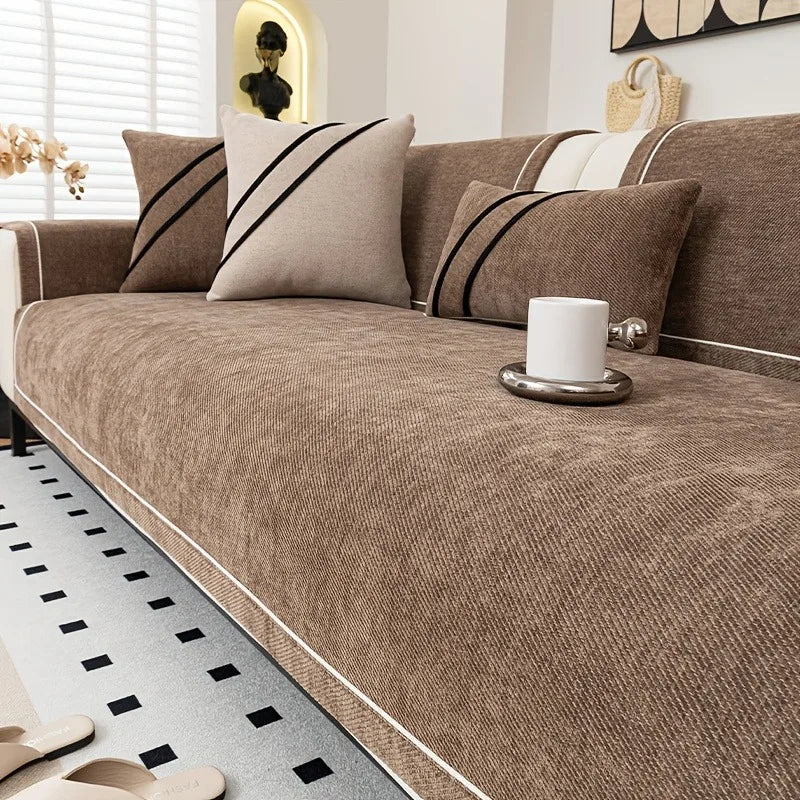 A luxurious brown chenille sofa protector cover with black stripes and a white ceramic mug on a sofa.