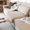 A beige removable jacquard seat cushion cover on a light sofa with a white fluffy decorative pillow.