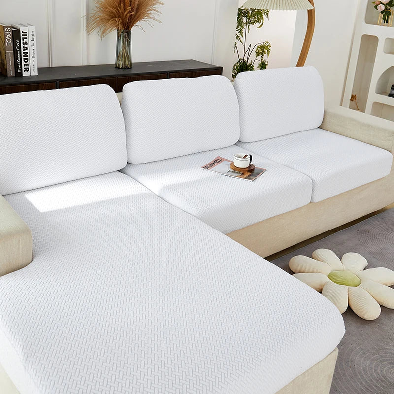 A white jacquard knit sofa cushion cover is shown on a light-colored sofa.
