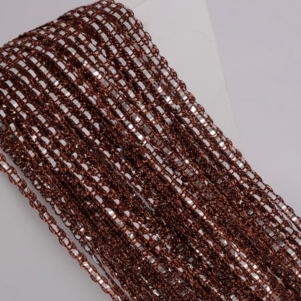 Close-up of dark brown decorative door string curtains for windows hanging vertically.
