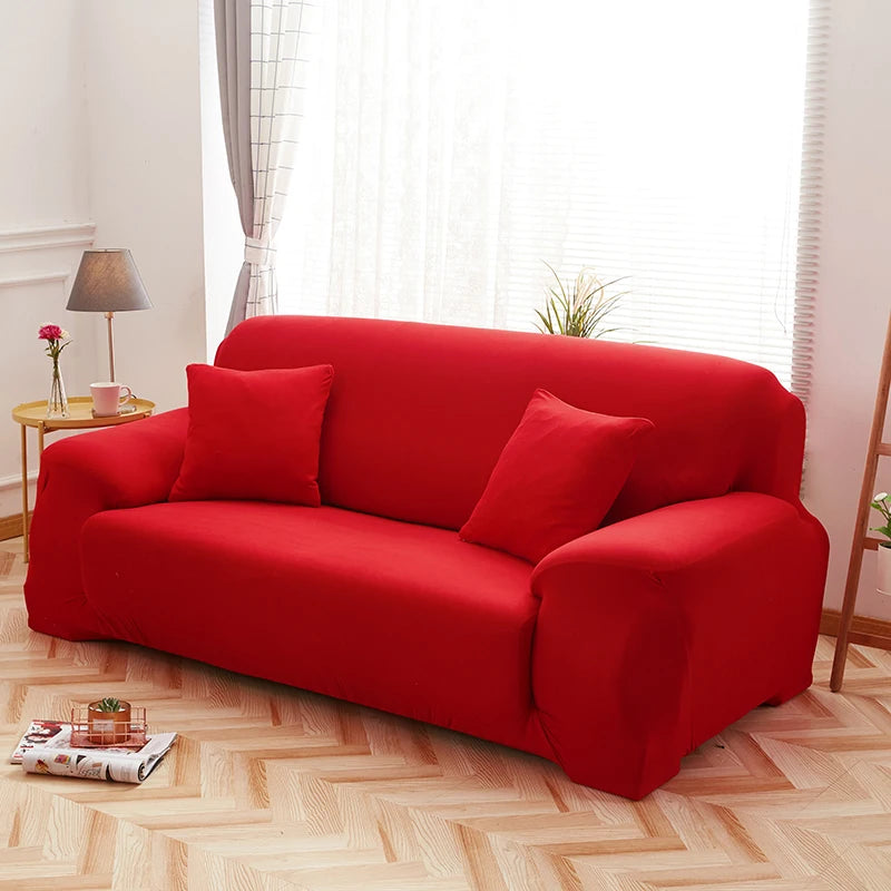 A vibrant red faux silk sofa cover placed on a light wooden floor near a window.