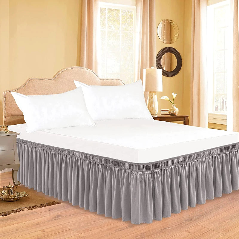 White bedding set featuring a thick ruffle bed skirt in gray and white linens.