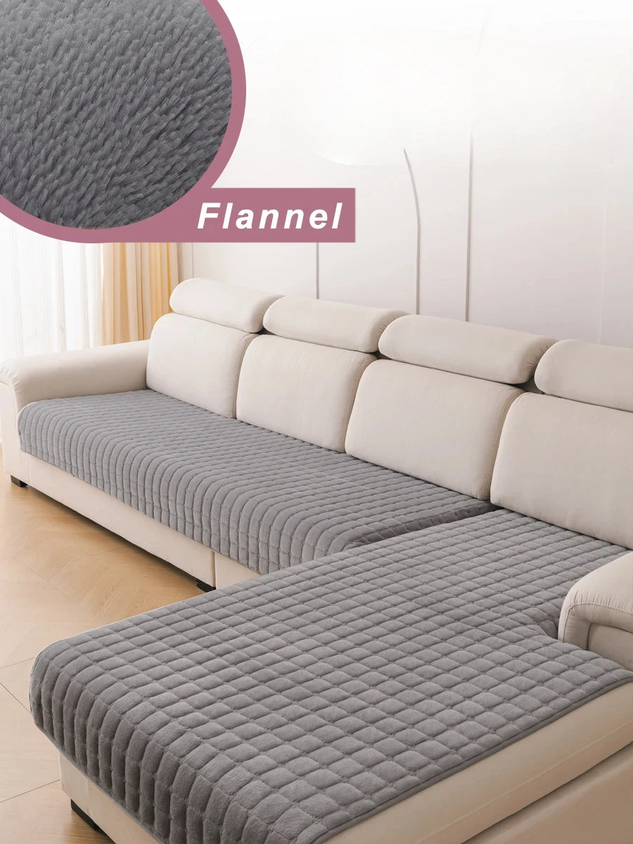 A light beige L-shaped sofa with a gray flannel cover and matching pillows.