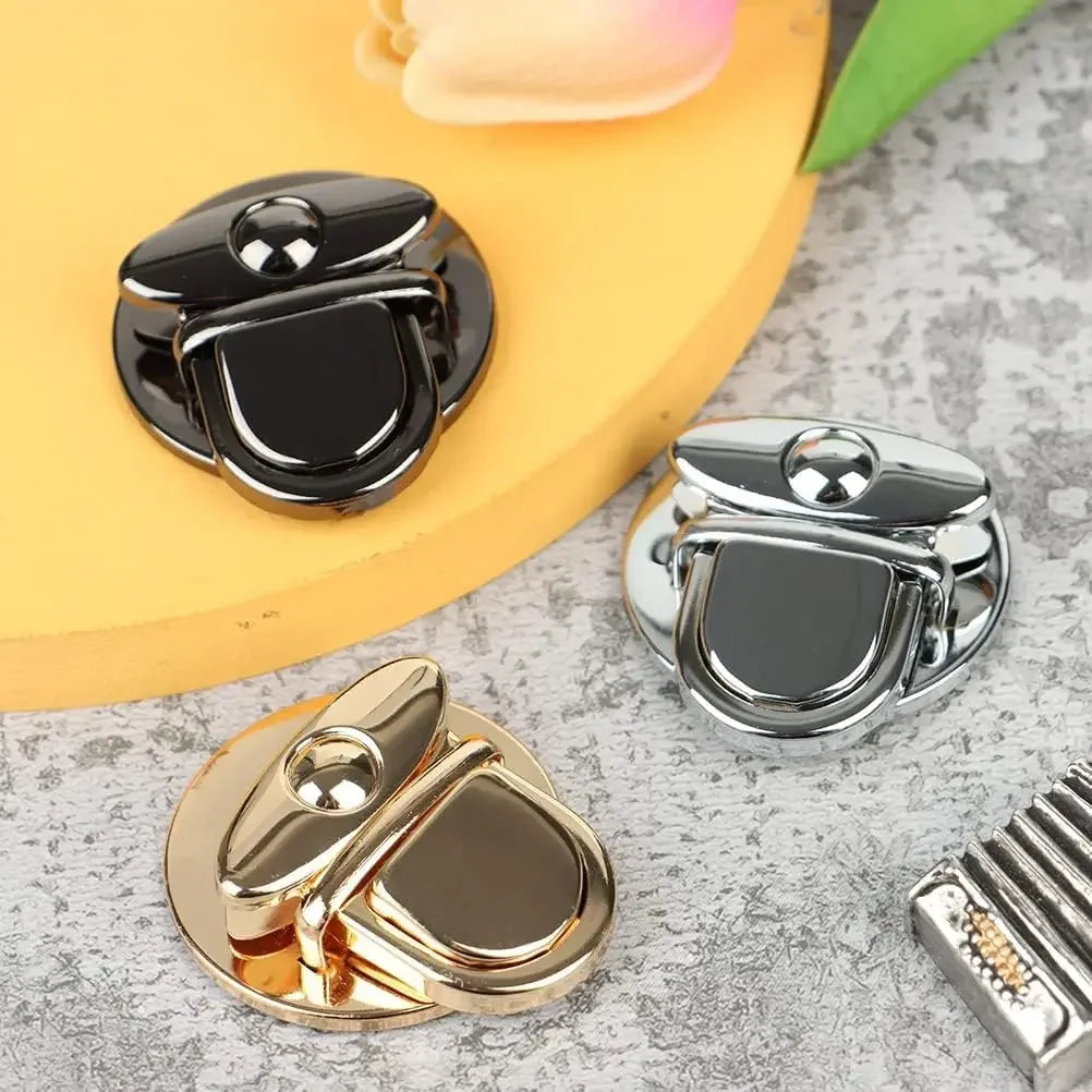 A collection of gold and silver metal twist locks for bags and DIY projects displayed on a light gray surface.
