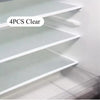 Four pieces of clear reusable silicone fridge and drawer liners displayed on a white shelf.