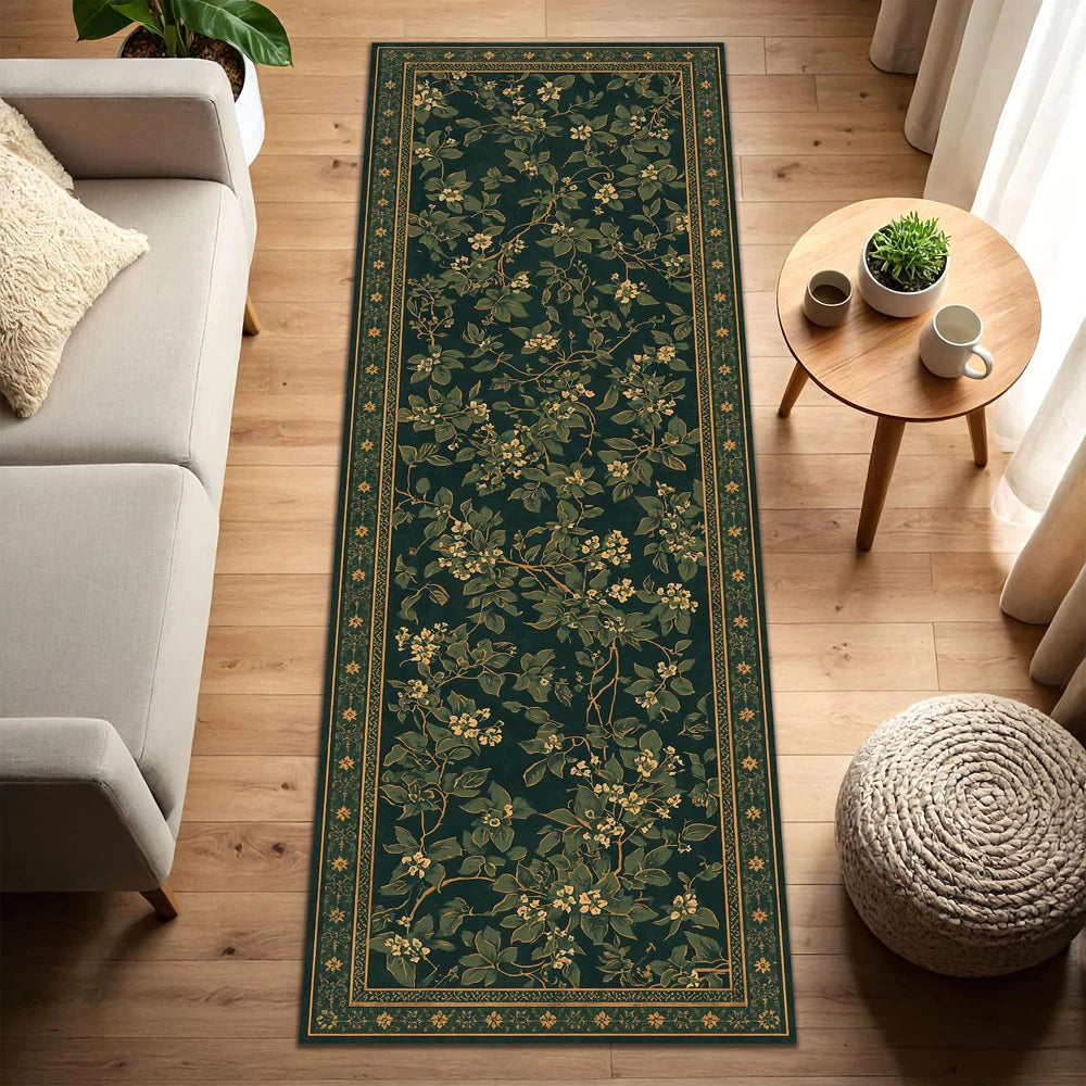 A long, dark green vintage botanical runner rug with gold accents placed on a light wood floor.